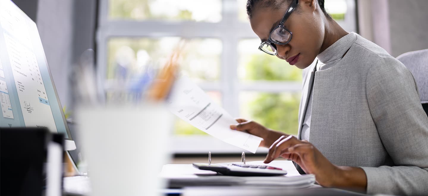 A young, professional woman using a calculator